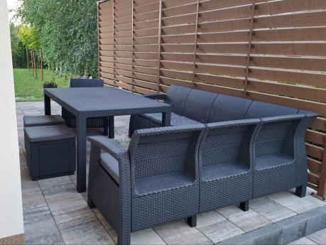 Duży narożnik ogrodowy ze stołem obiadowym Rellme VI z fotelem i pufami grafitowy