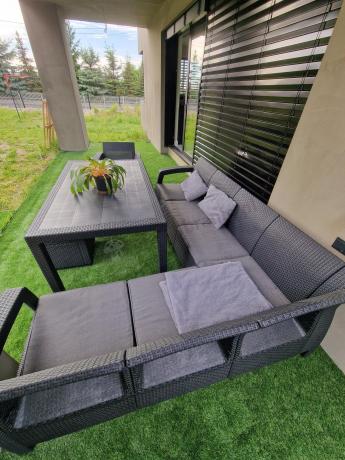 Duży narożnik ogrodowy ze stołem obiadowym Rellme VI z fotelem i pufami grafitowy