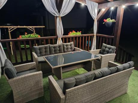 Meble ogrodowe z dwoma kanapami i stołem obiadowym