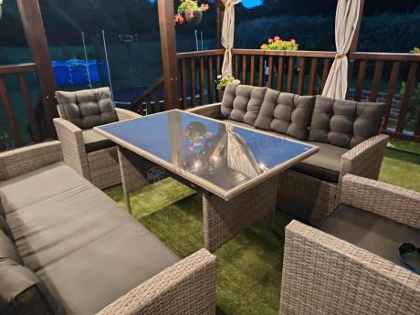 Meble ogrodowe z dwoma kanapami i stołem obiadowym