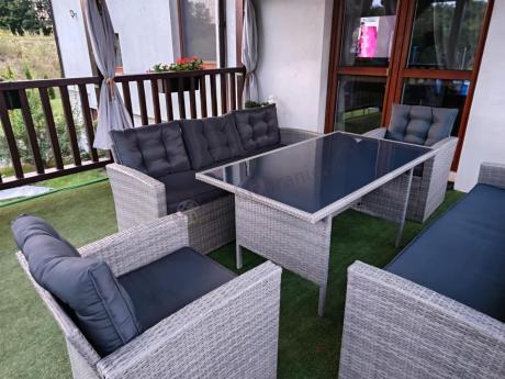 Meble ogrodowe z dwoma kanapami i stołem obiadowym