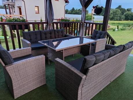 Meble ogrodowe z dwoma kanapami i stołem obiadowym