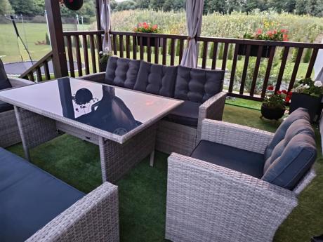 Meble ogrodowe z dwoma kanapami i stołem obiadowym