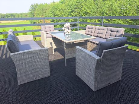 Meble ogrodowe z dwoma kanapami i stołem obiadowym