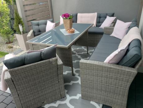 Meble ogrodowe z dwoma kanapami i stołem obiadowym