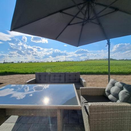 Meble ogrodowe z dwoma kanapami i stołem obiadowym