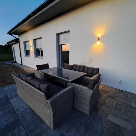 Meble ogrodowe z dwoma kanapami i stołem obiadowym