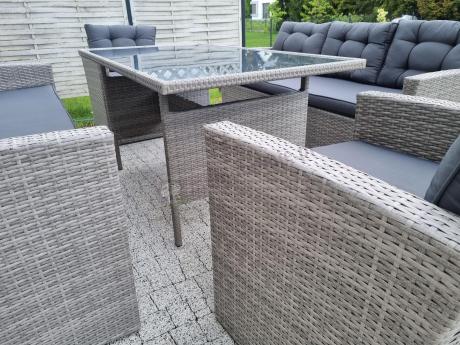 Meble ogrodowe z dwoma kanapami i stołem obiadowym