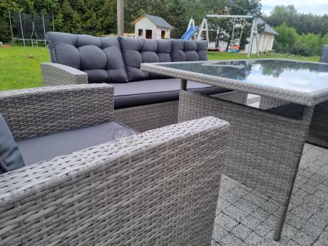 Meble ogrodowe z dwoma kanapami i stołem obiadowym