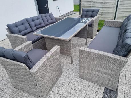 Meble ogrodowe z dwoma kanapami i stołem obiadowym