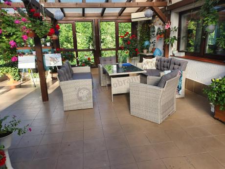 Meble ogrodowe z dwoma kanapami i stołem obiadowym