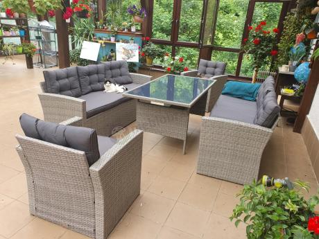 Meble ogrodowe z dwoma kanapami i stołem obiadowym