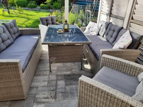 Meble ogrodowe z dwoma kanapami i stołem obiadowym