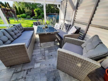 Meble ogrodowe z dwoma kanapami i stołem obiadowym