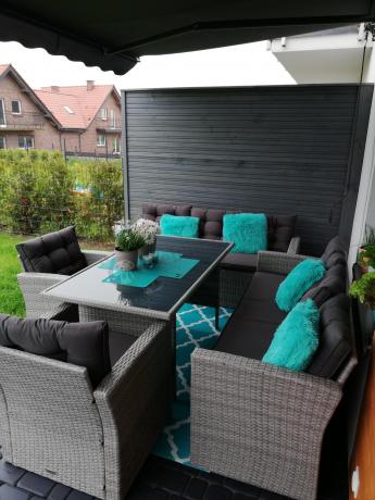 Meble ogrodowe z dwoma kanapami i stołem obiadowym