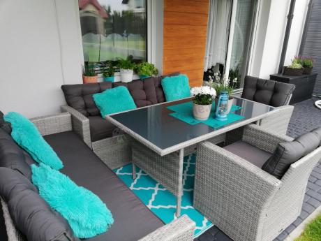 Meble ogrodowe z dwoma kanapami i stołem obiadowym