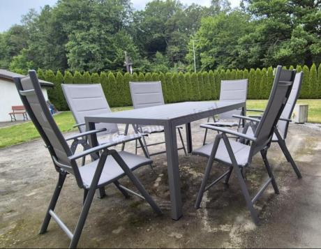 Szary komplet mebli ogrodowych ze stołem obiadowym i składanymi krzesłami - Kanbery Silver 6+1