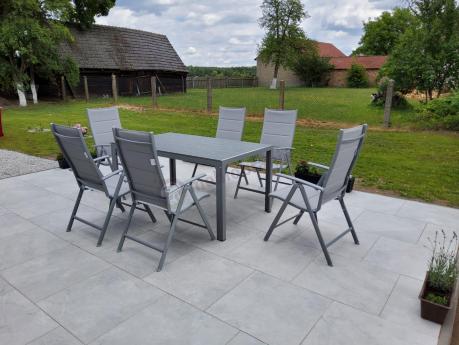 Szary komplet mebli ogrodowych ze stołem obiadowym i składanymi krzesłami - Kanbery Silver 6+1