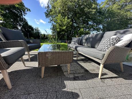 Szary komplet mebli z technorattanu dla 5 osób z sofą i fotelami Cioso