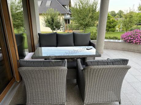 Szary zestaw mebli ogrodowych - sofa, fotele, pufy i wysoki stół - Novici Dining