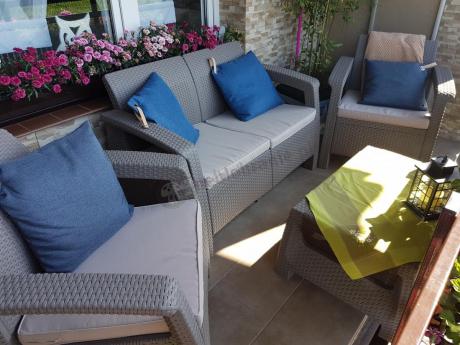 Meble Corfu Set przyozdobionę kwiatami oraz niebieski poduszkami
