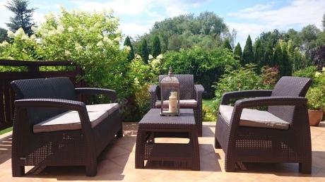 Zestaw mebli na taras Allibert Keter Corfu Set na tle ogrodowej zieleni