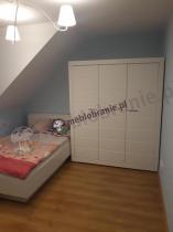 Białe łóżko 120cm i szafa w sypialni na poddaszu 
