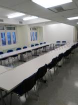 Białe stoły konferencyjne z niebieskimi krzesłami