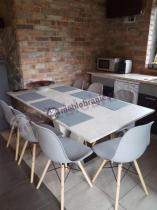 Biały, rozkładany stół i krzesła w kuchni ze ścianami z cegieł