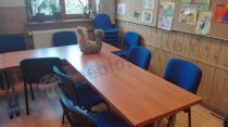 Brązowe stoły konferencyjne i niebieskie krzesła tapicerowane