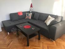 Ciemny narożnik w salonie ze szklaną ławą