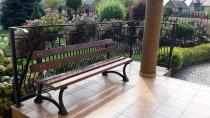 Drewniana ławka żeliwna o długości 180 cm przymocowana do balustrady
