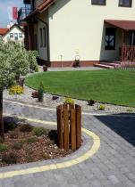 Drewniany kosz na śmieci w eleganckim ogrodzie