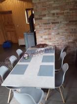 Duży biały stół i plastikowe krzesła w modnej kuchni