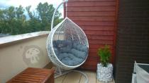 Jasny fotel wiszący jajo na balkonie Cocoon Miloo