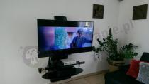 Nowoczesne, czarny wieszak na telewizor i dekoder