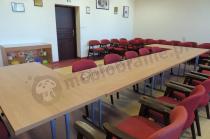 Stoły konferencujne z bordowymi krzesłami w szkole