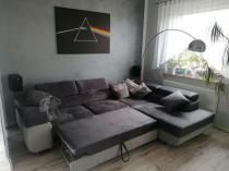 Szary narożnik do spania w designerskim salonie