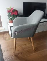 Szary profilowany fotel na cienkich nogach w stylu skandynawskim