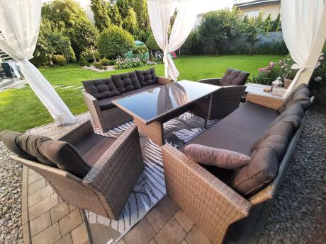 Meble ogrodowe z dwoma kanapami i stołem obiadowym