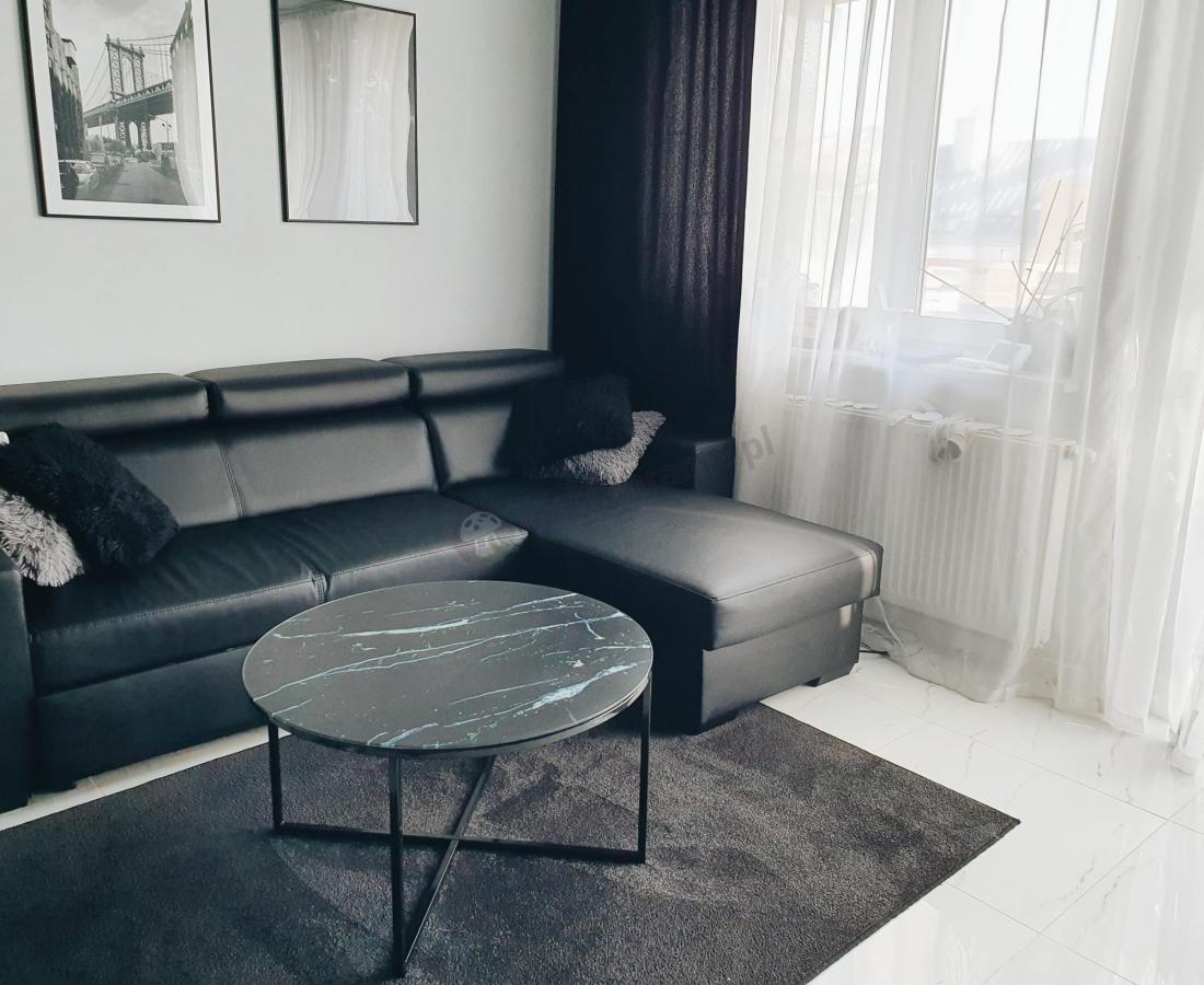 czarny stolik kawowy z marmurowym blatem w nowoczesnym salonie