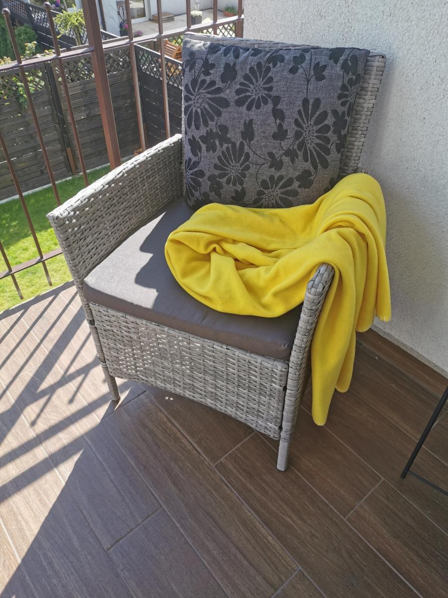 fotel technorattanowy szary na niewielkim balkonie