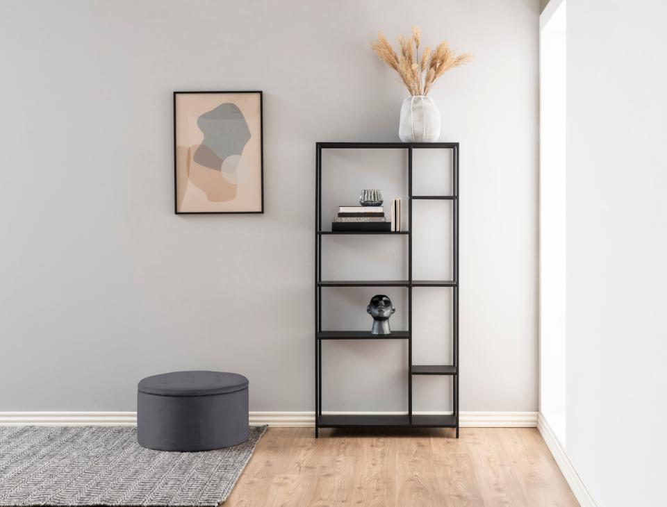 minimalistyczny salon z ciemnoszarą pufką pikowaną ze schowkiem Retina Actona